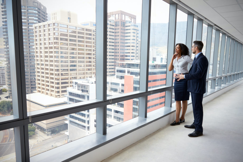 Real estate agents chatting while facing a massive window